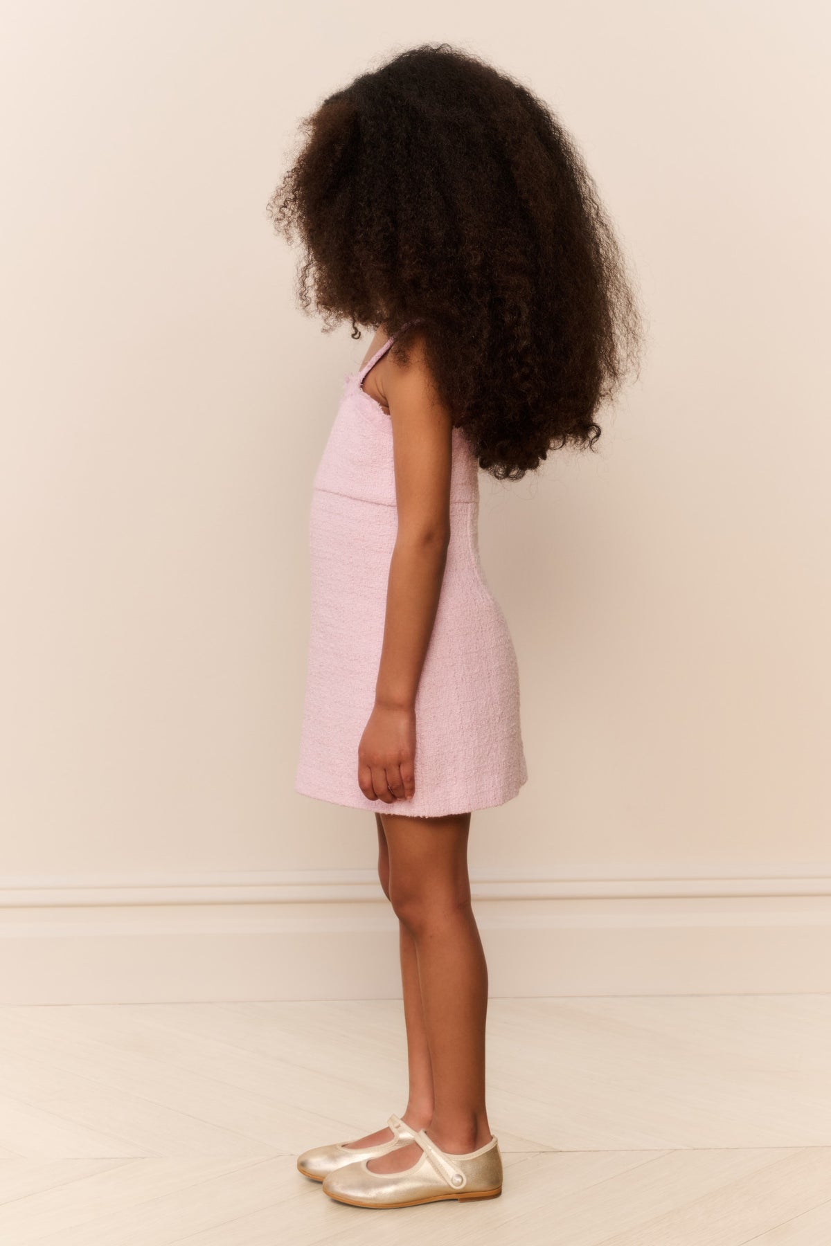 Pink sleeveless mini dress with lace neckline, back-facing side view
