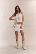 Cotton cami top in bright white with lace hem, ruffled trim, and thin straps.
