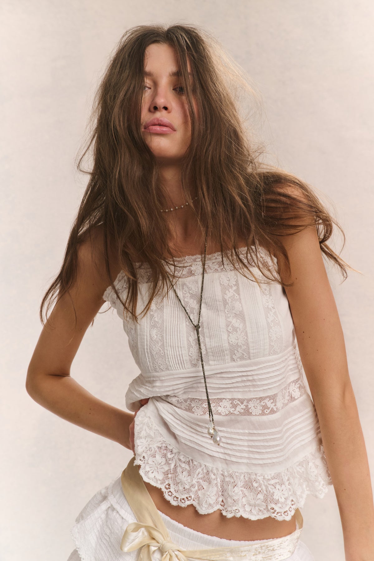 Cotton cami top in bright white with embroidered texture, lace neckline, and straps.