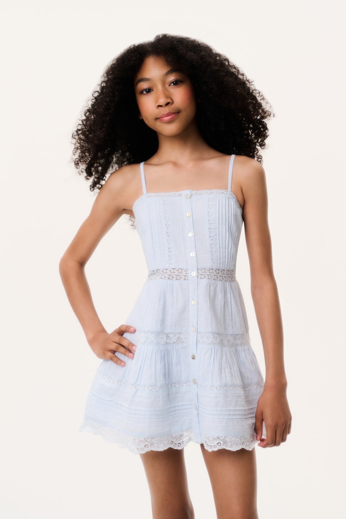 Blue tween mini dress with spaghetti straps, tiered skirt, and lace hem