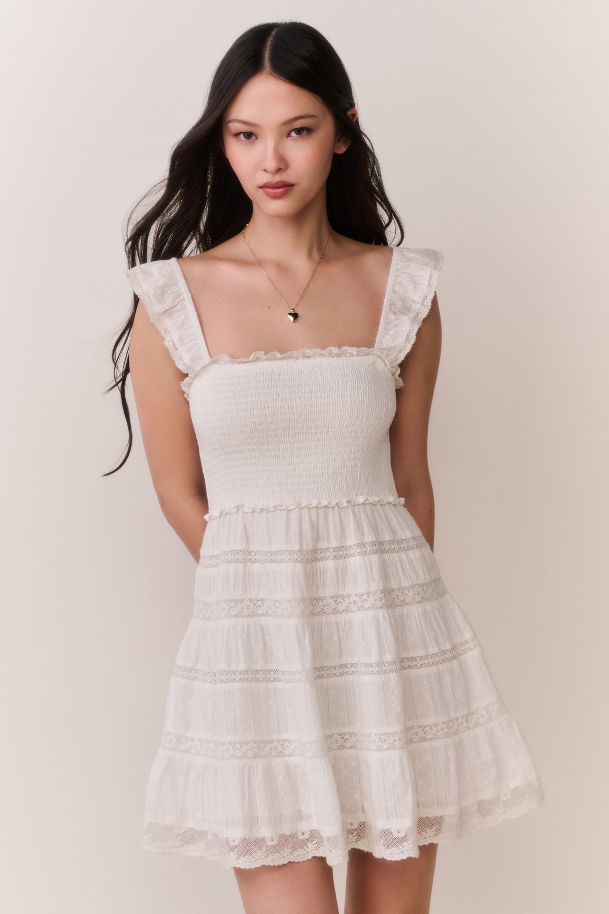 Front-view lace-trimmed cotton mini dress with smocked bodice and tiered skirt