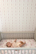 Cotton crib sheet in striped pink floral print, fitted on crib mattress