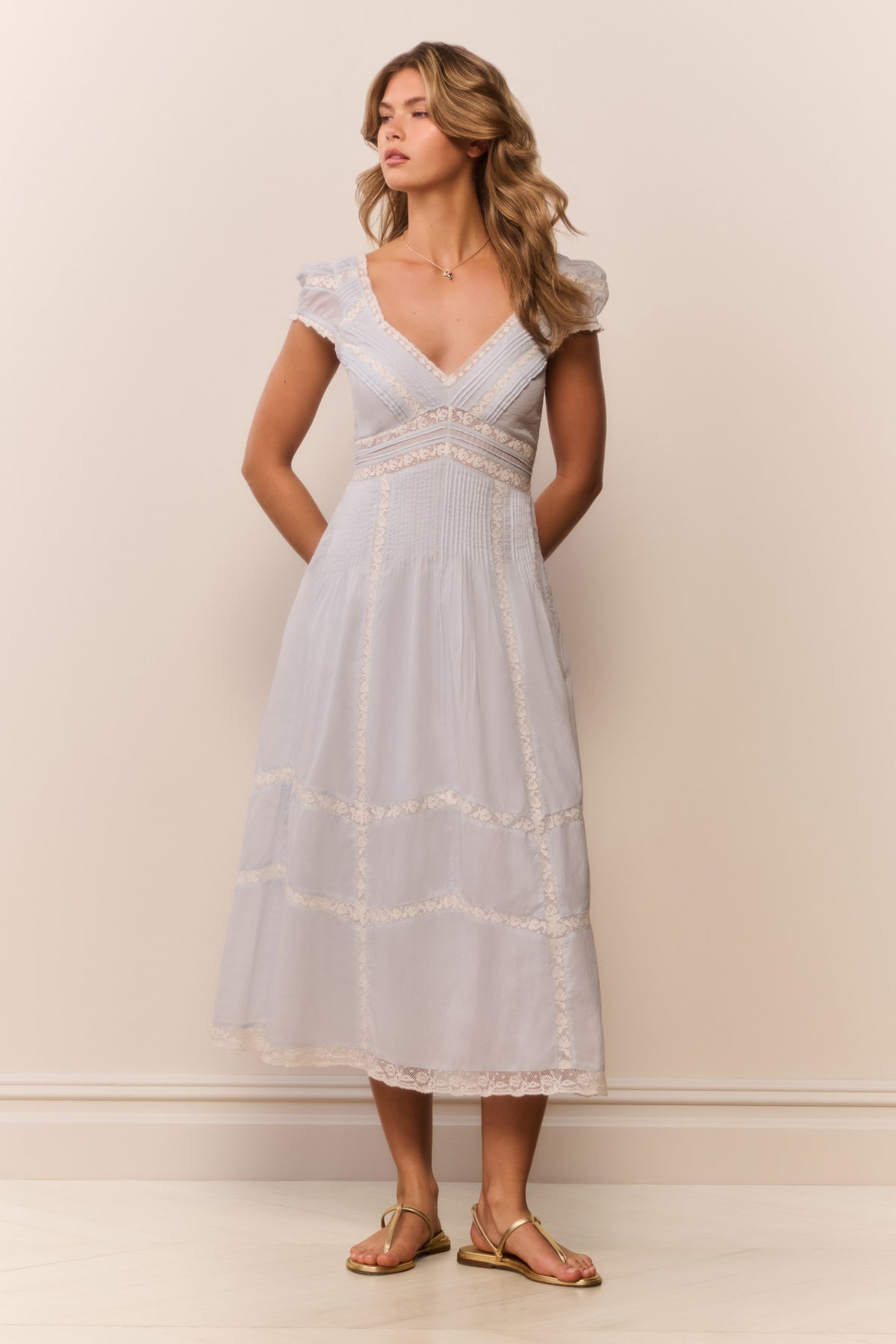 Light blue midi dress with V-neck, short puff sleeves, and embroidered stripe tiers