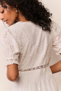 White cotton eyelet midi dress, back view with lace panels and puff sleeves