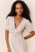 White eyelet midi dress with V-neckline, puff sleeves, and button-front
