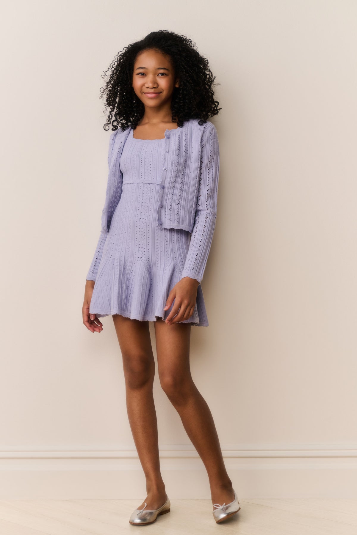 Lavender pointelle knit cardigan with long sleeves and open front, layered look.