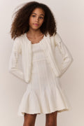 White pointelle knit cardigan with long sleeves, open front, textured panel pattern.