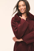Dark merlot faux fur collar wool coat with long sleeves, wrap-style front.