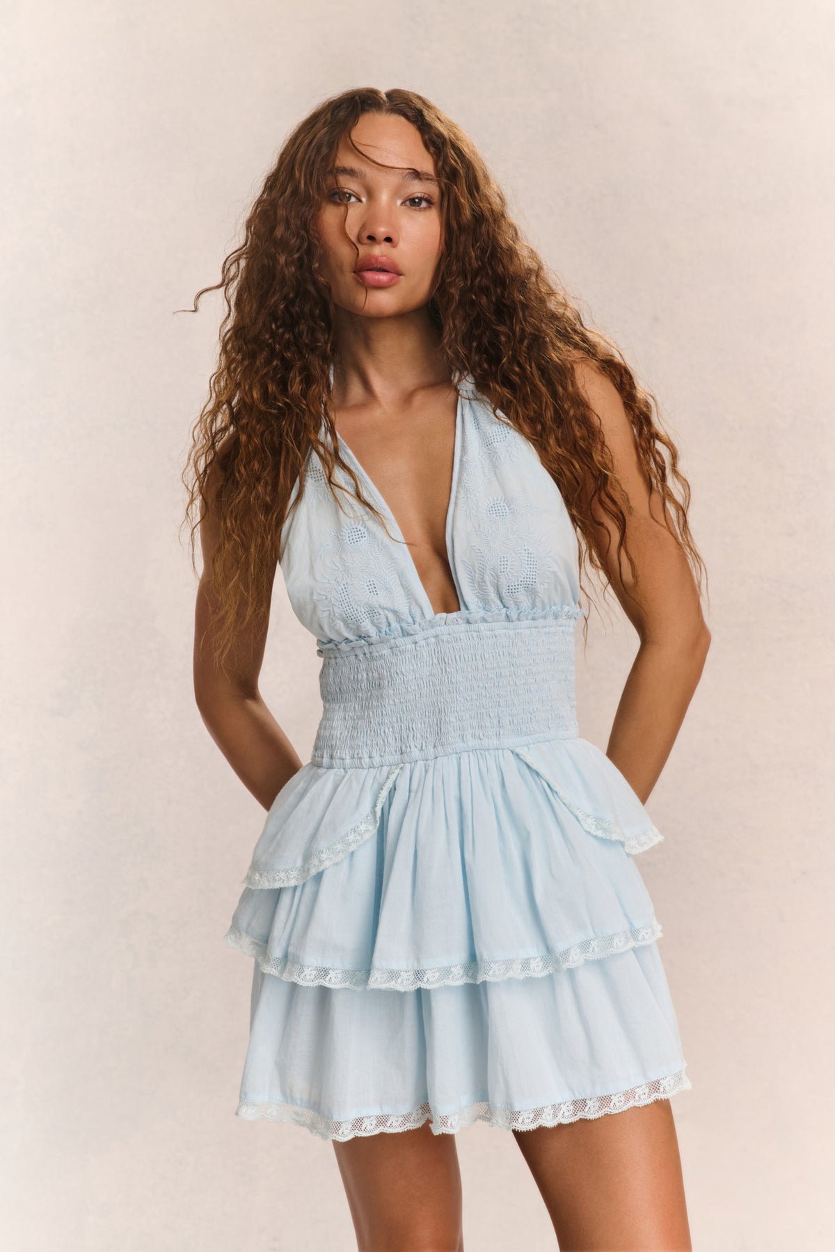 Light blue halter mini dress with deep V neckline, tiered ruffles, lace trim