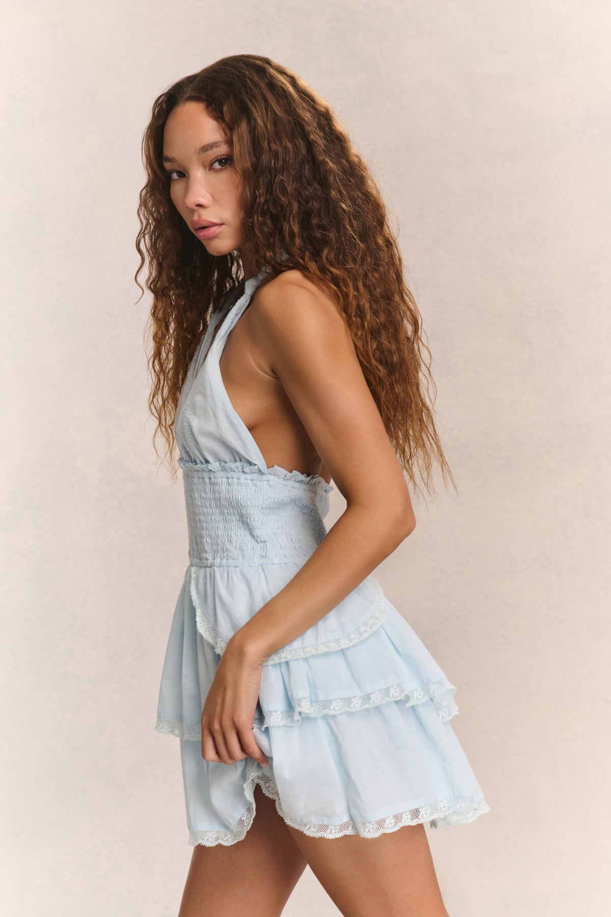 Light blue halter mini dress, side view with tiered ruffle skirt and lace trim