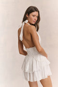 White halter mini dress with open-back tie straps and tiered ruffle skirt
