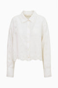 White linen button-up shirt top with eyelet embroidery, point collar, front buttons.