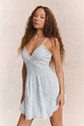 White cotton mini dress with V-neck, spaghetti straps, tiered skirt detail
