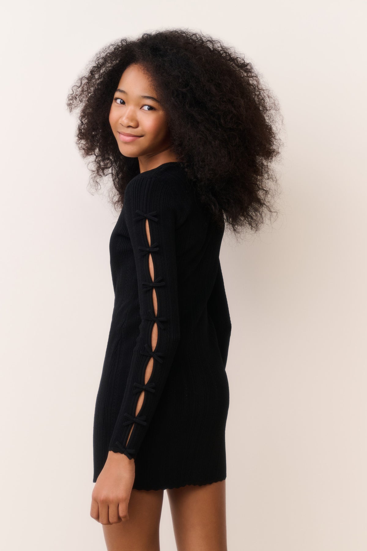 Black tween knit mini dress with long sleeves and lace-up side detail