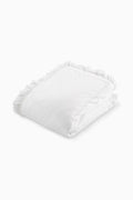 White Victorian duvet and sham set with ruffled edges, neatly folded