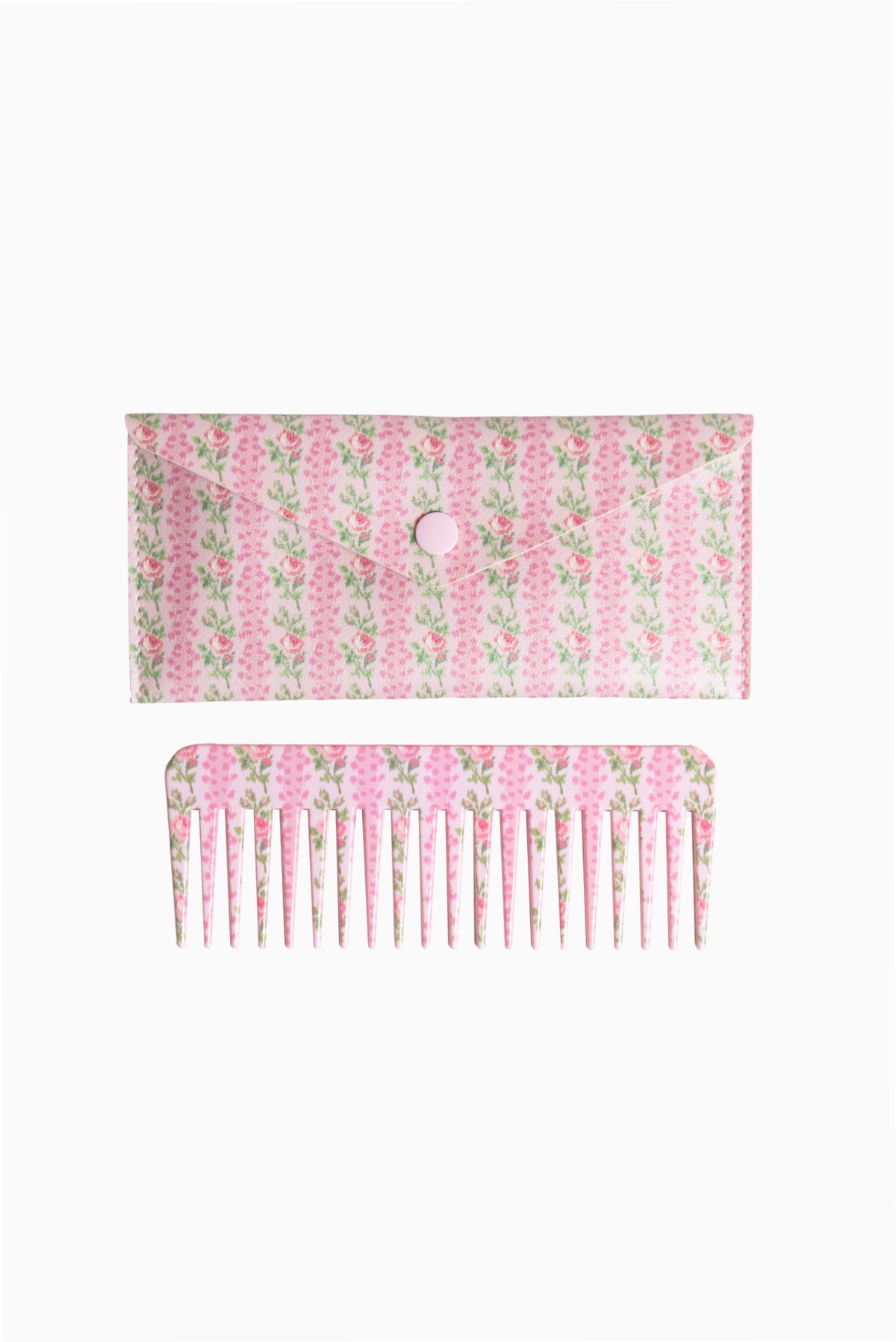 Pink and green floral hair comb with fine teeth, shown with backing card