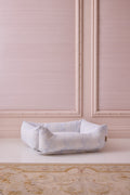 Printed dog bed with pale blue floral fabric and rolled bolstered sides