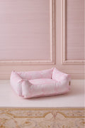 Pink printed dog bed with padded sides and low, open top