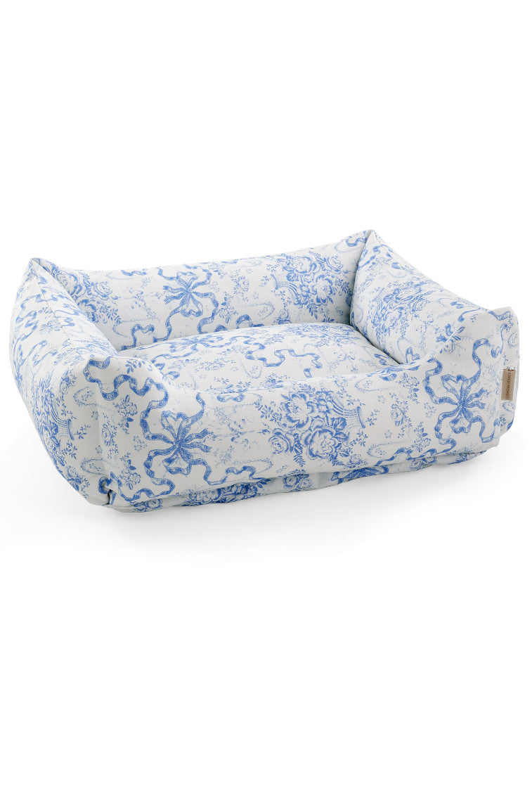 Printed dog bed with light blue pattern fabric and low bolstered cushion sides