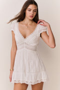 White cotton mini dress, V-neck lace trim and embroidered texture, ruffled skirt