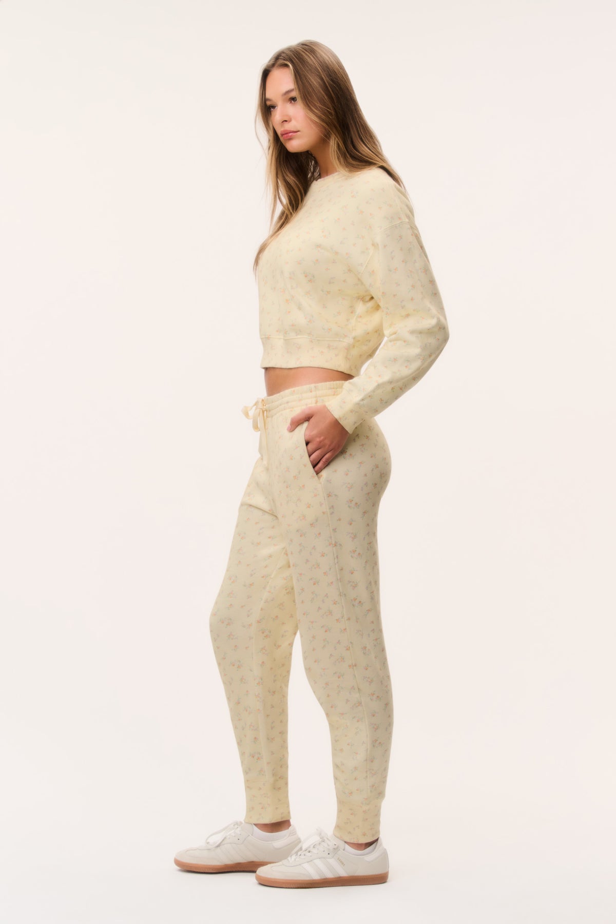Cream ditsy floral sweatpants shown from the side, elastic drawstring waist