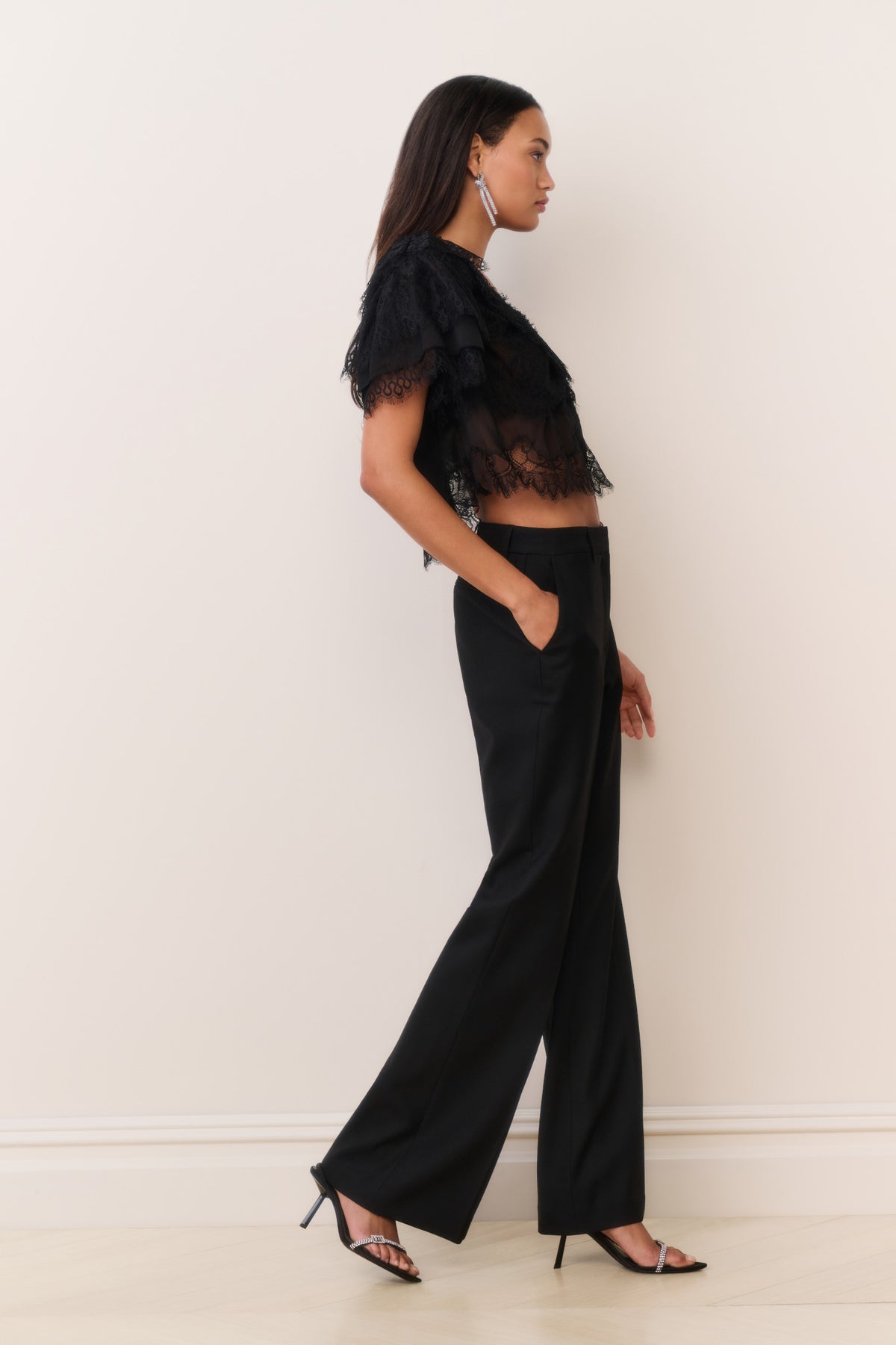 Black wide-leg wool-blend pants with center crease, side view, ankle length.