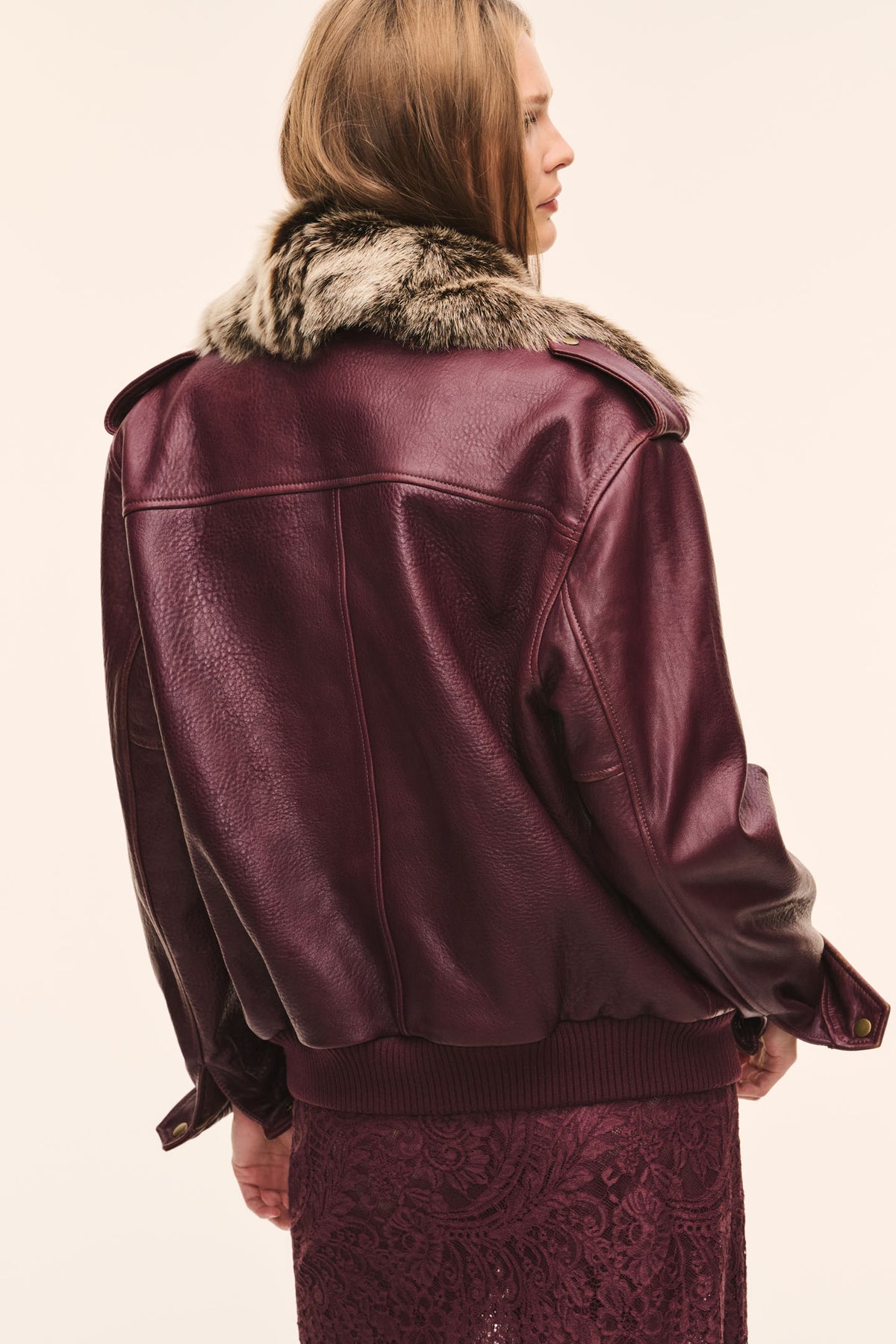 Faded merlot leather bomber jacket, back view with faux fur-trimmed collar