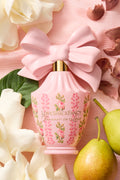 Pink decorative perfume bottle with light pink bow and floral label