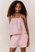 Pink gingham cami top with thin straps, ruffled tiers, and smocked bodice