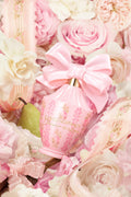Pink perfume bottle with large satin bow and floral design