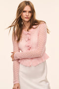 Light pink pointelle cardigan with bow-front tassel trim and ruffle hem, long sleeves