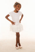 Girls white tiered ruffle skirt with elastic waistband, worn with white tee