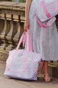 Floral XL tote with pink straps and heart patch, carried outdoors over matching bag