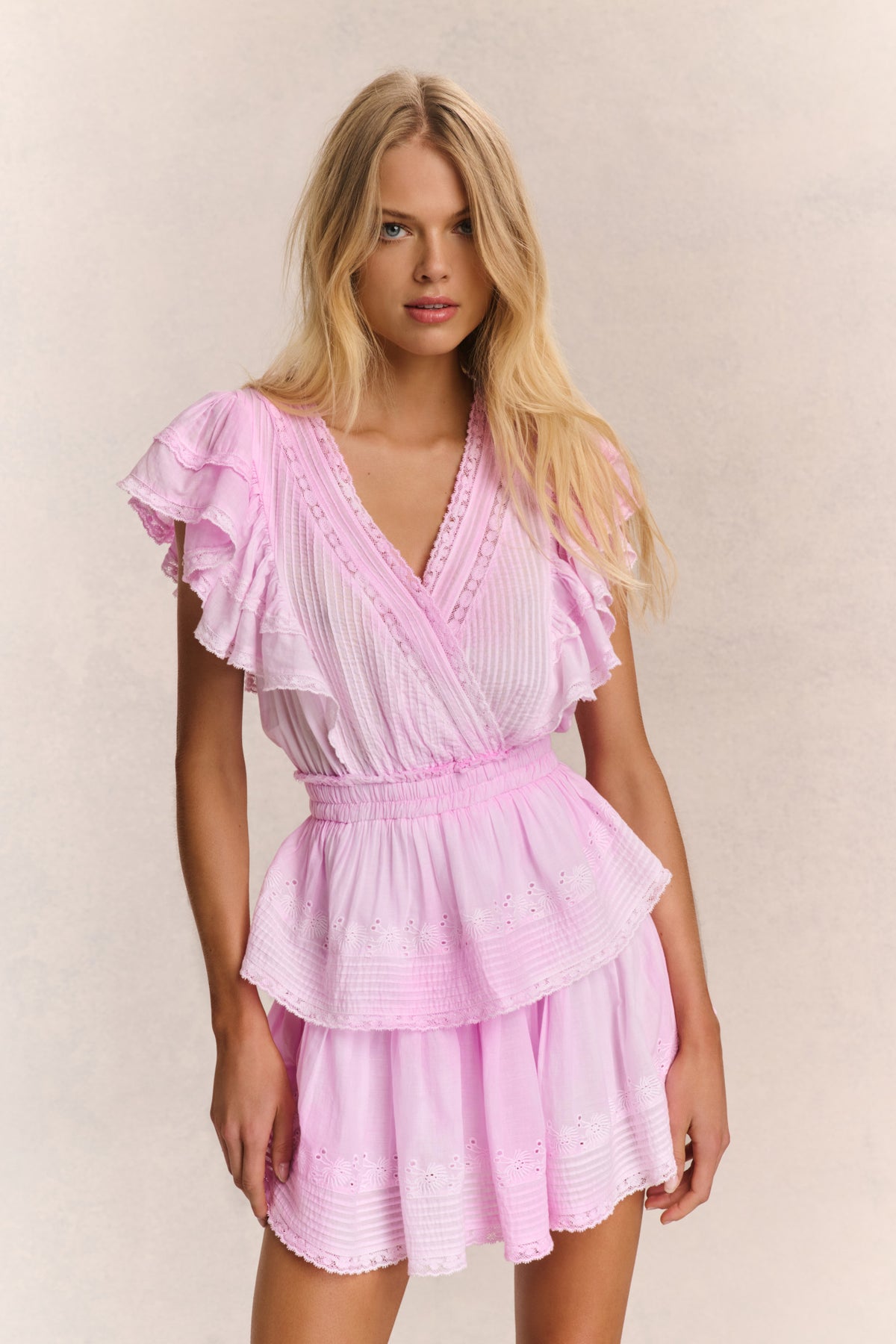 Pink V-neck mini dress with ruffled sleeves and tiered babydoll skirt
