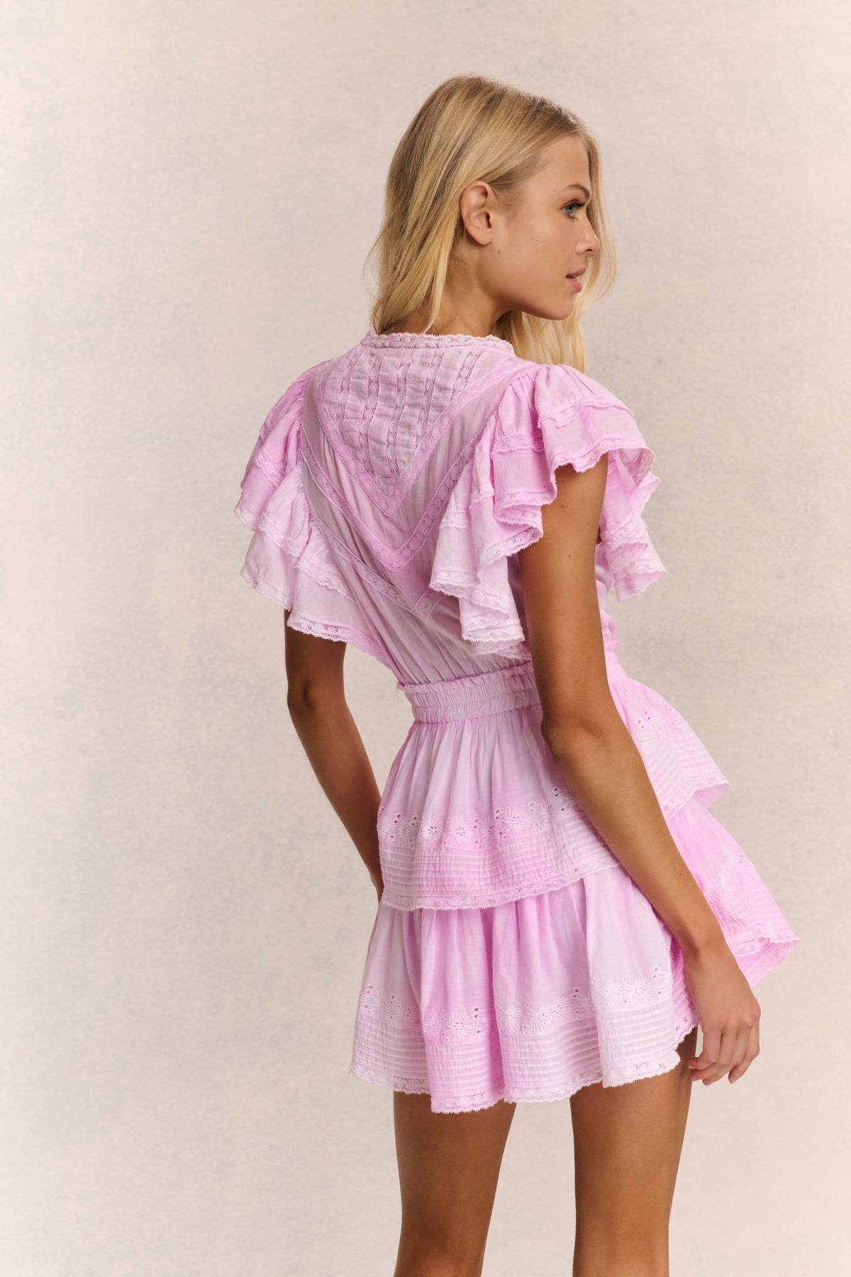 Pink V-neck mini dress with tiered ruffle layers, back view