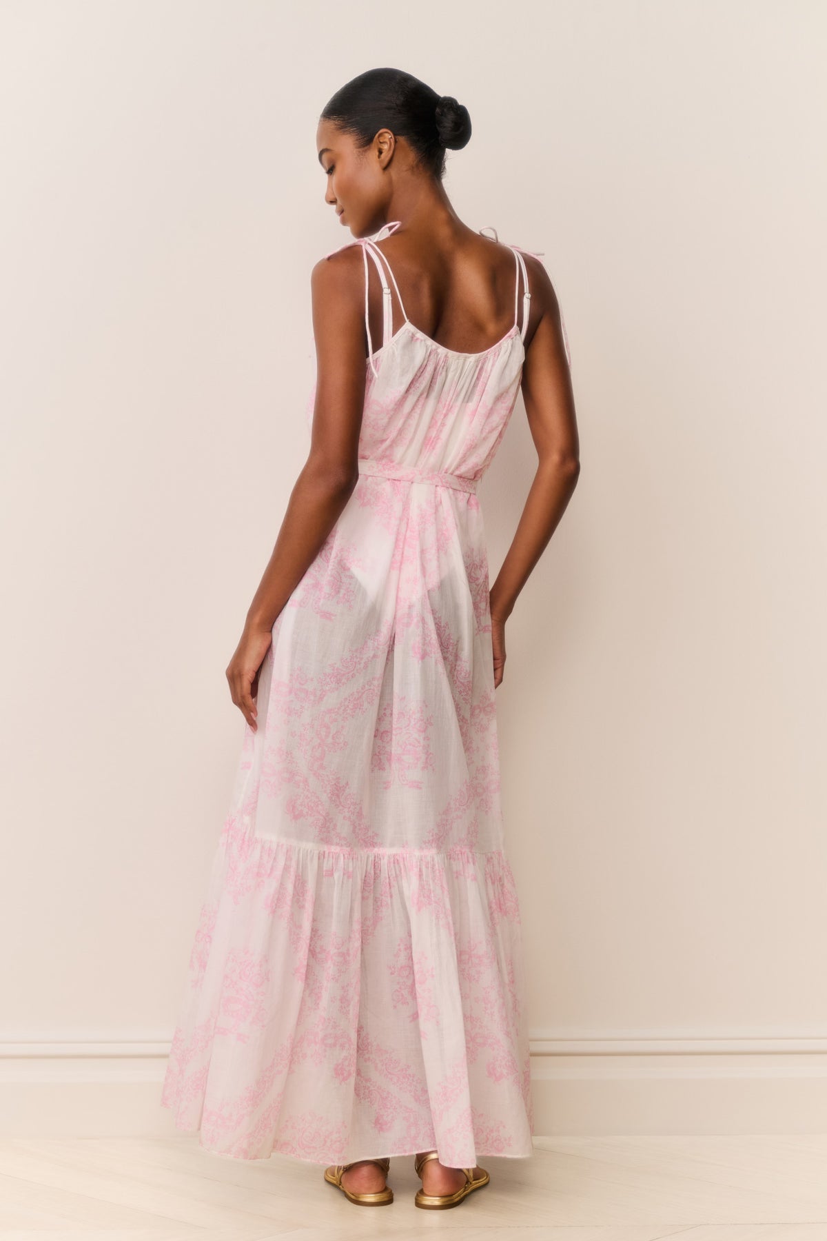 Back view of toile print cover-up dress with thin straps and tie waist, tiered tiered skirt