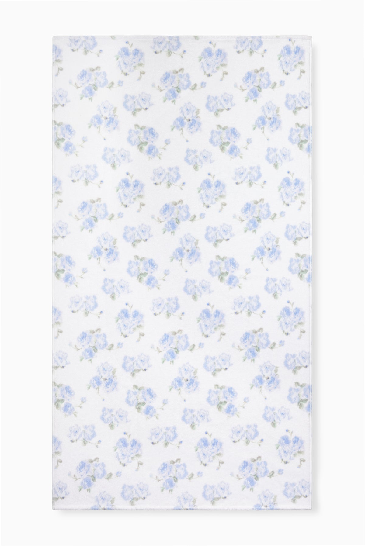 Hali beach towel in blue with all-over floral print, laid flat