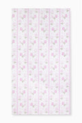 Hali beach towel in pretty pink with vertical stripes and floral print, laid flat