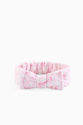 Pink patterned bow headband with gathered ruffle and stitched fabric bow