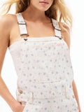 Women’s ecru overall top close-up with adjustable straps and front patch pockets