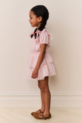 Pink lace-trimmed cotton dress with tiered skirt and short puff sleeves
