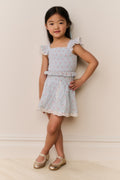 Girls floral cotton mini skirt front view, light ivory with small floral print and ruffled hem