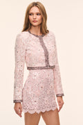 Pink lace long-sleeve jacket with open front, dark pink trim, lace trim accents and sequin embellished floral pattern paired with matching mini skirt