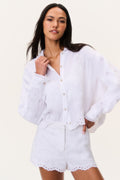 White linen button-up top with eyelet cutwork, V-neck, cuffed long sleeves.