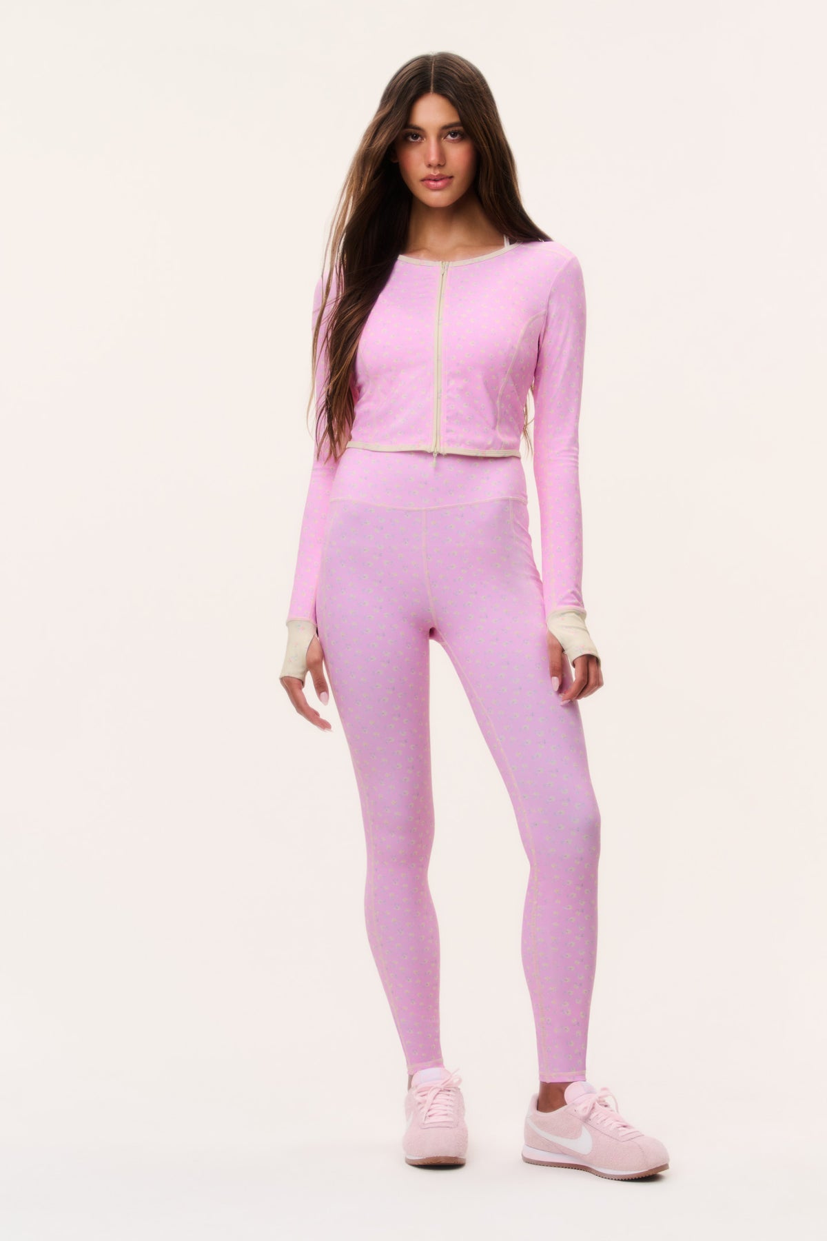 Pink patterned cropped active jacket with full front zipper, worn with matching leggings