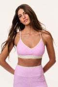Front view sports bra with ditsy floral pattern, pale base and pink-trim V-neck