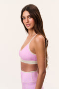 Ditsy floral sports bra in pale tone with pink trim; angled side view
