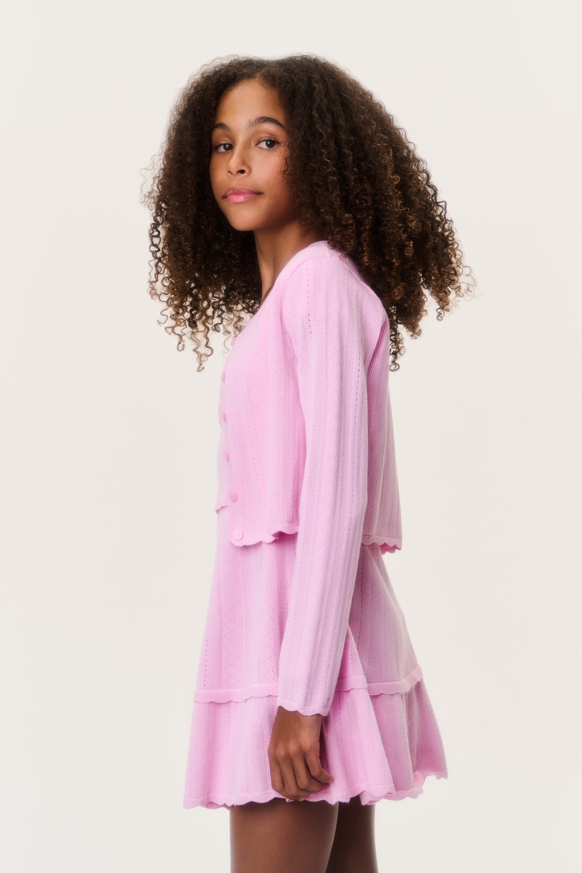 Tween pointelle cardigan, light pink button-front with tiered ruffle hem (side view)