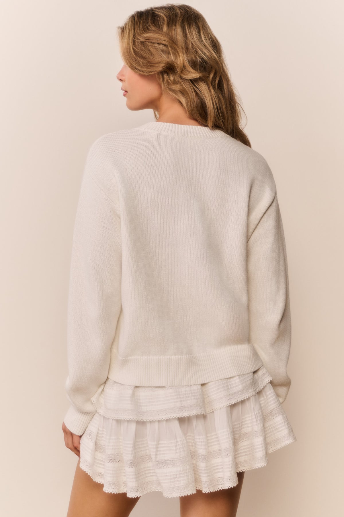 Ivory knit pullover sweater with tiered ruffle hem detail