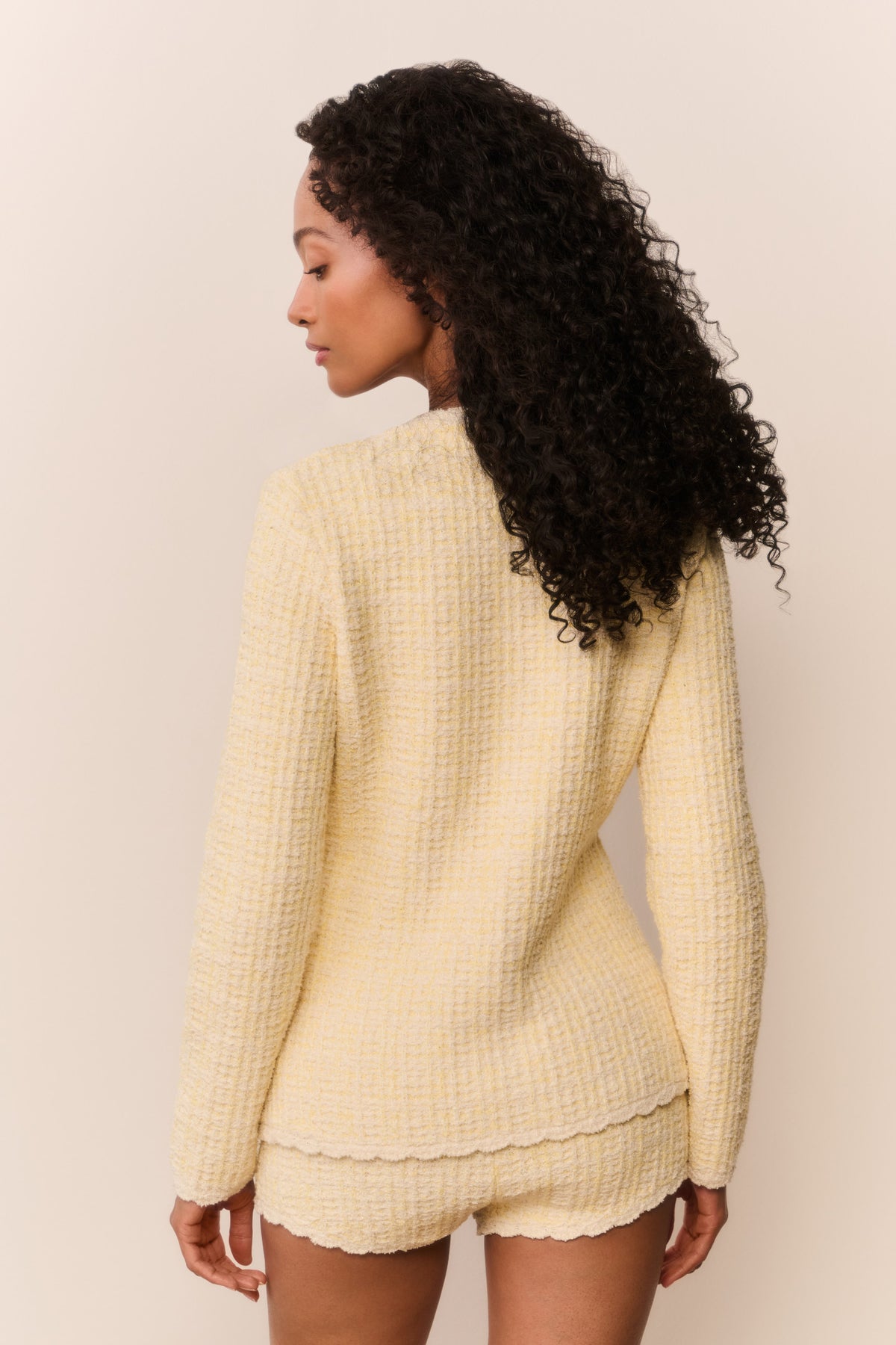 Light yellow knit tweed mini shorts, back view, scalloped lace-trim hem